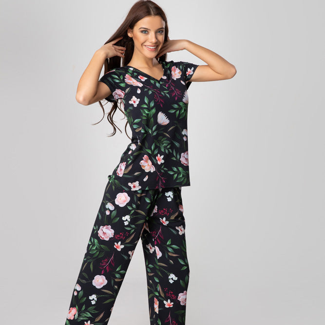 Woman wearing a floral pajama set on a gray background